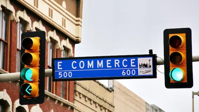 Street sign reading E Commerce between traffic lights